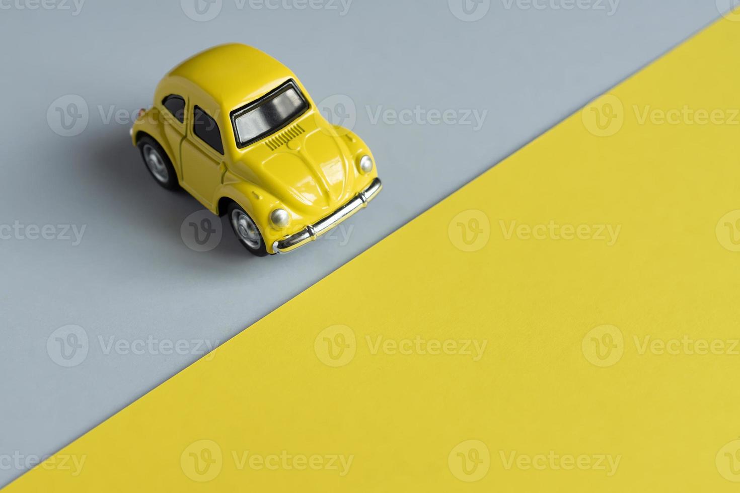 Flat lay in a trendy 2021 new colors. Illuminating Yellow and Ultimate Gray. Color of the Year 2021. Retro toy car on grey background with copy sapce. photo