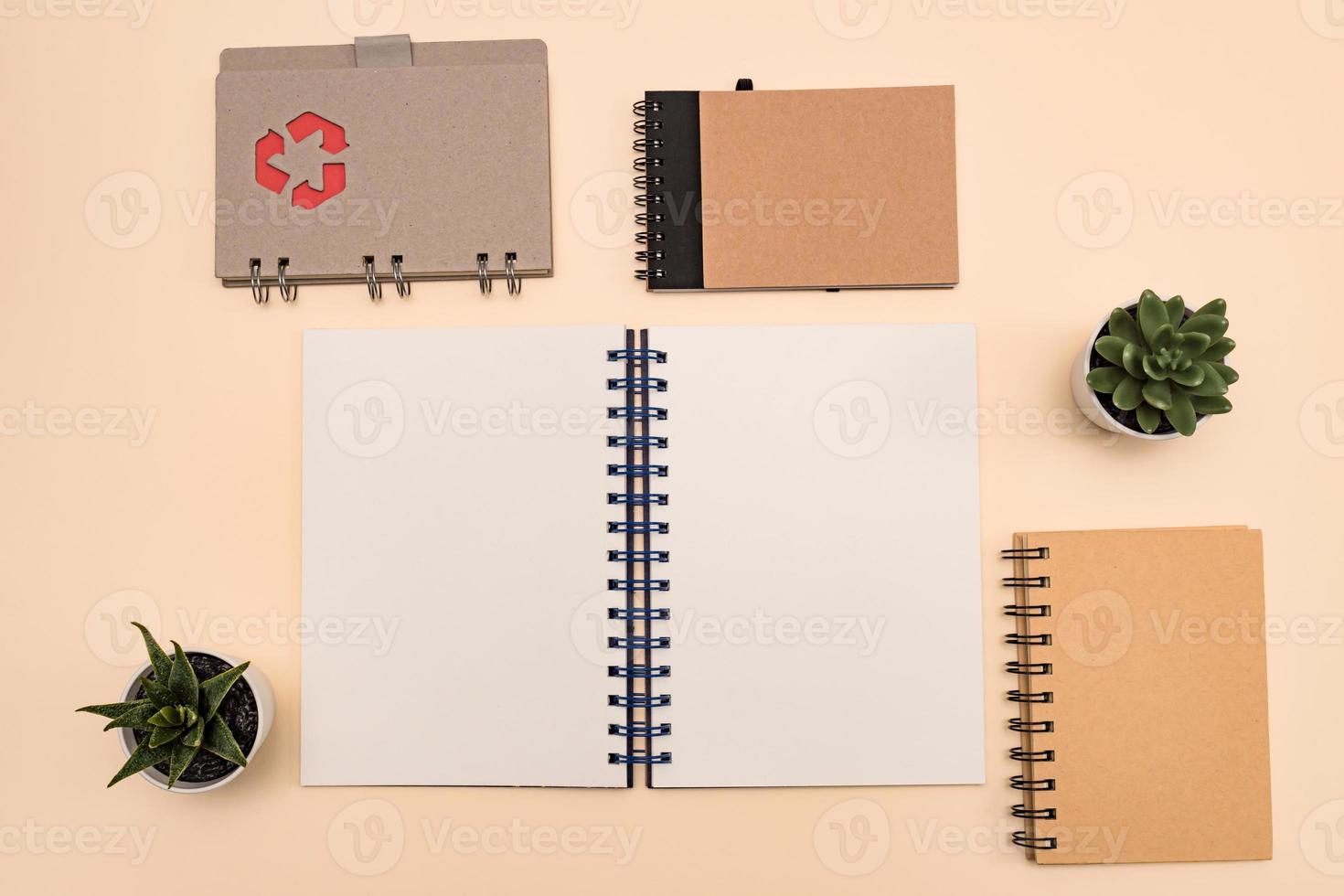 Eco friendly notebooks for office, with copy space made of recycled paper on a pastel background. recycle mark on the cover photo