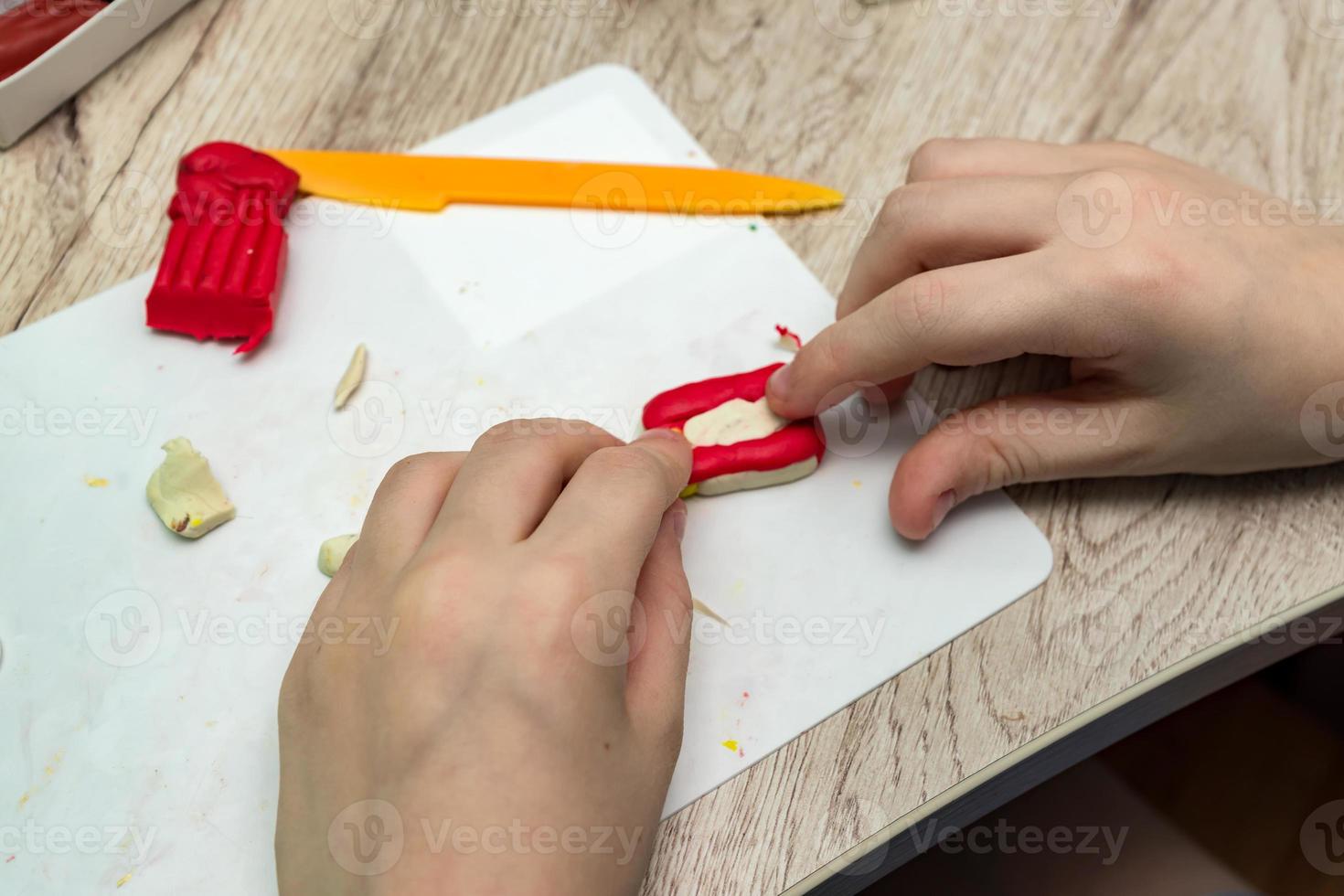 child play with plasticine. Plasticine modeling clay in children class. Development of fine motor skills of fingers. photo