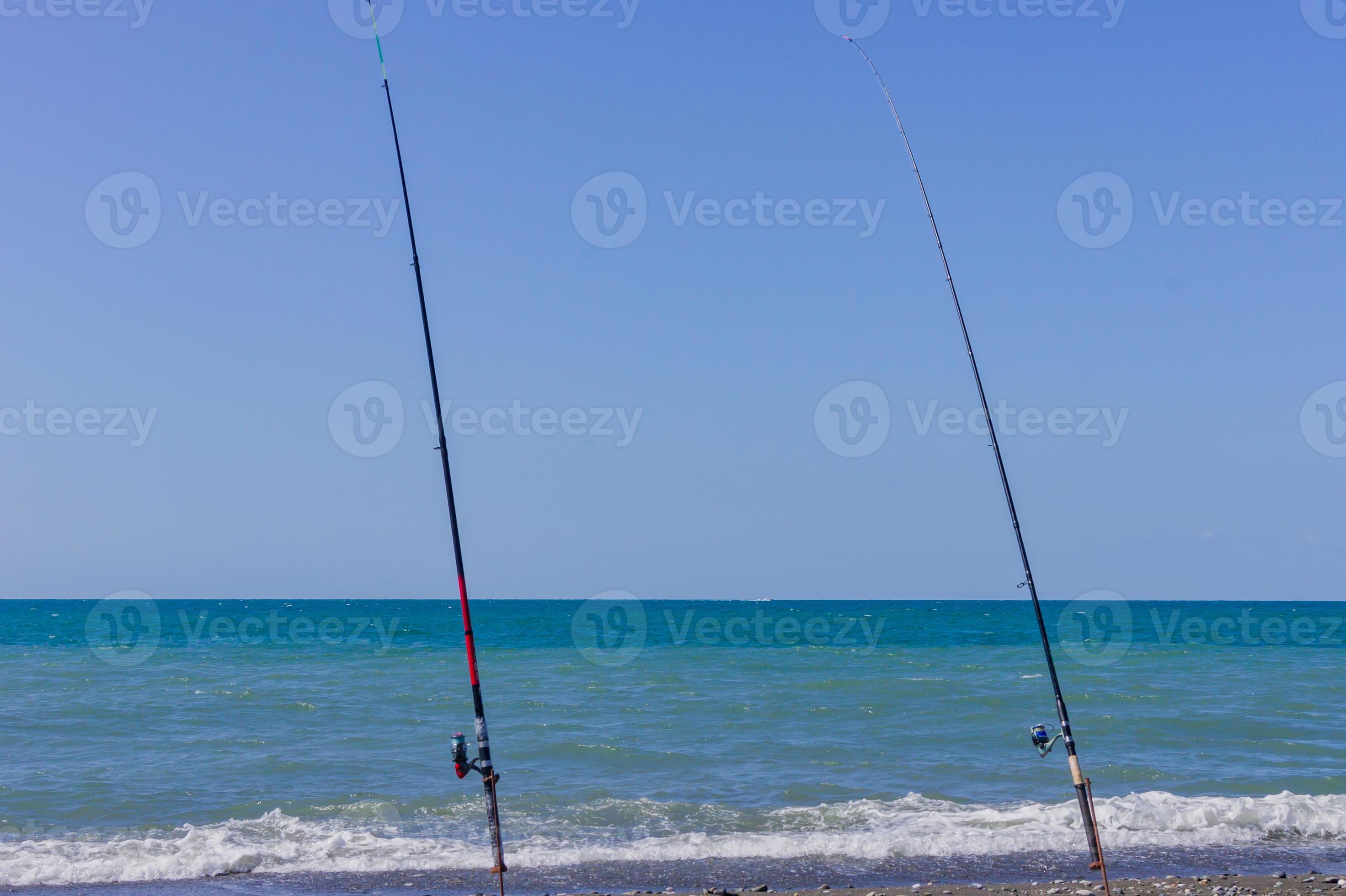 two fishing rods on sea beach. Fishing tourism and vacation concept  11033927 Stock Photo at Vecteezy
