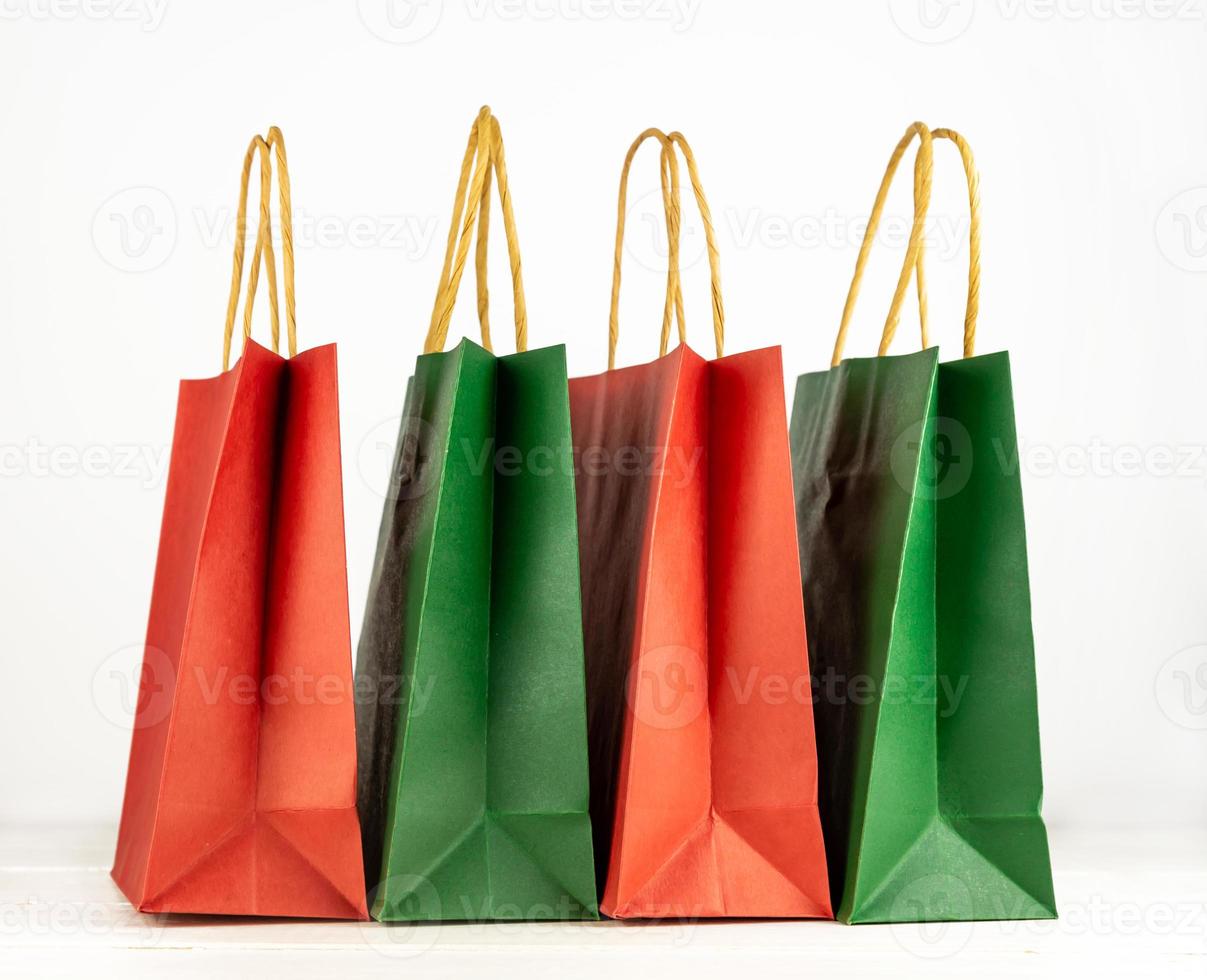 conjunto de bolsas de compras de papel artesanal en estado de ánimo navideño. sobre fondo blanco concepto de compras para vacaciones de invierno. foto