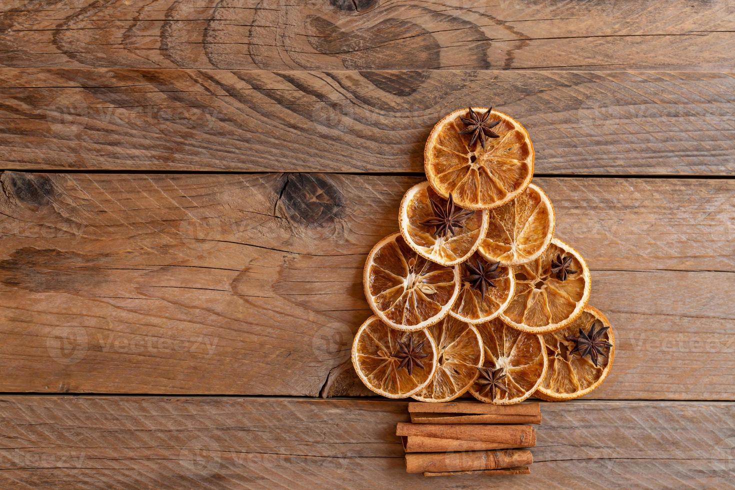 Christmas tree made of dried oranges, cinnamon and anise. Viewed from above. Concept of christmas holiday greeting card. Copy space for text photo