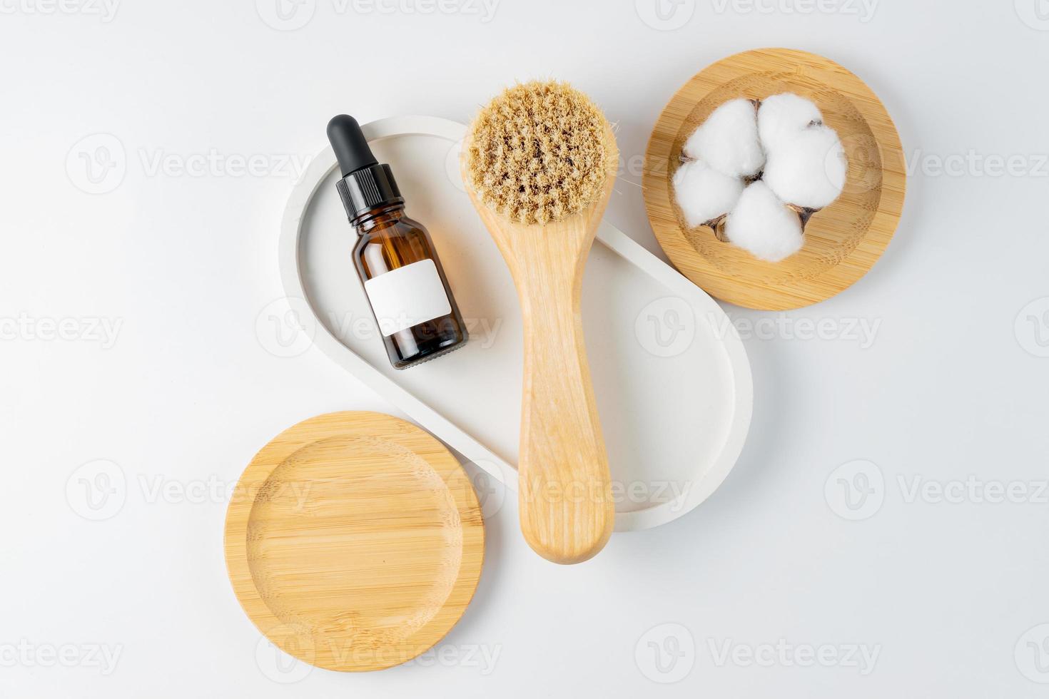 producto cosmético y cepillo de limpieza facial de madera de cerdas naturales. accesorios para tratamientos de belleza, cepillo de limpieza facial sobre fondo blanco. productos cosméticos para el cuidado del rostro. maqueta sin marca foto