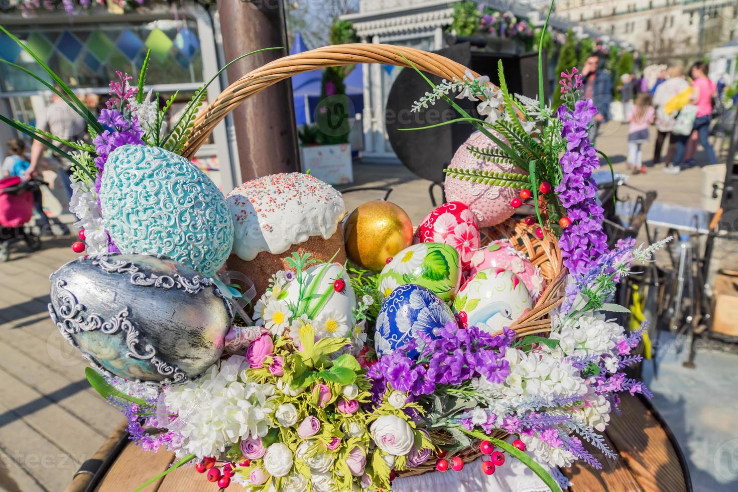 vestival de la calle pascua en moscú, rusia. cesta de mimbre llena de huevos de pascua pintados, pastel y flores. foto