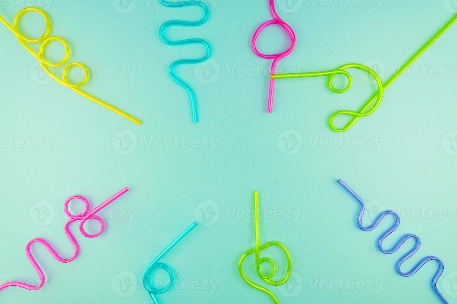 multicolored plastic cocktails straws on blue background photo