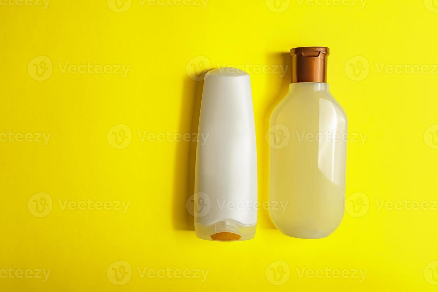 Set of White Cosmetic containers on yellow background, top view with copy space. Group of plastic bodycare bottles with empty space for you design photo