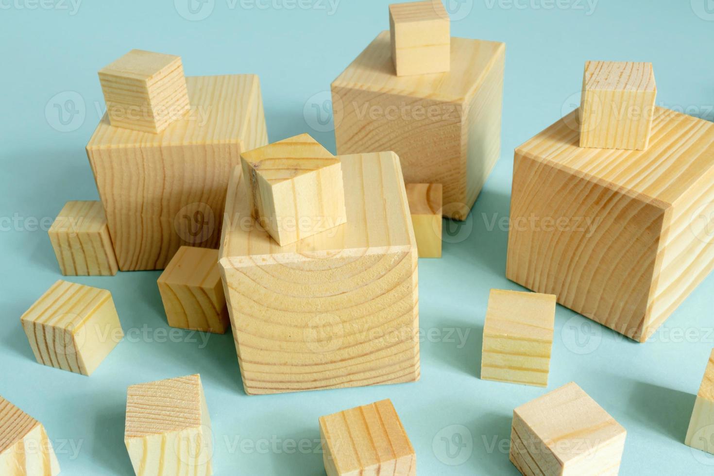 many wooden cube of different size on blue background. Construction and developing consept. mockup for designers. photo