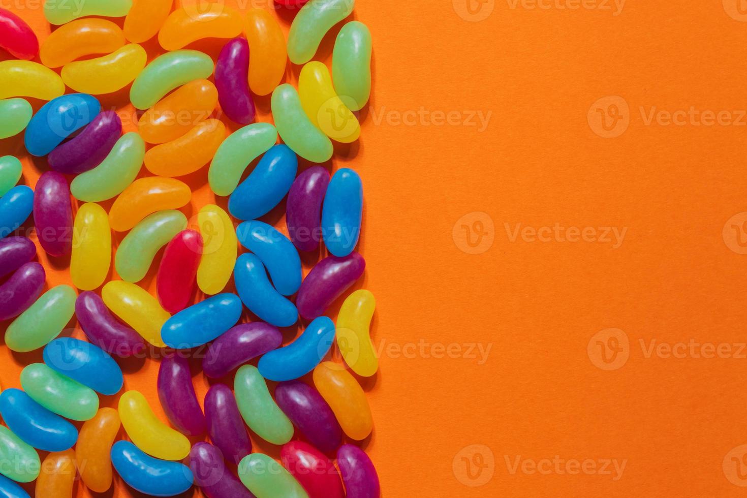 Assorted Jelly Beans border with copyspace on orange background photo