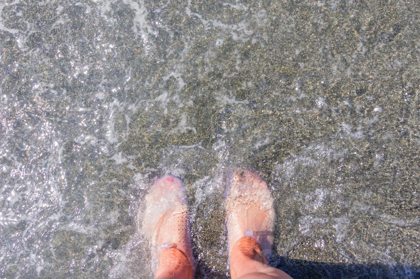 pies femeninos en zapatillas protectoras de goma para caminar sobre corales. vista superior foto