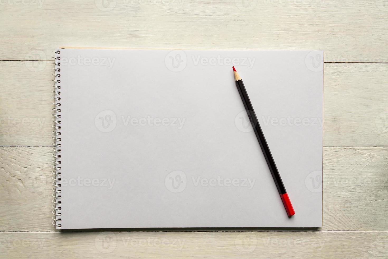 red pencil on blank white album paper. Top view. school and office supplies. Copy space. photo