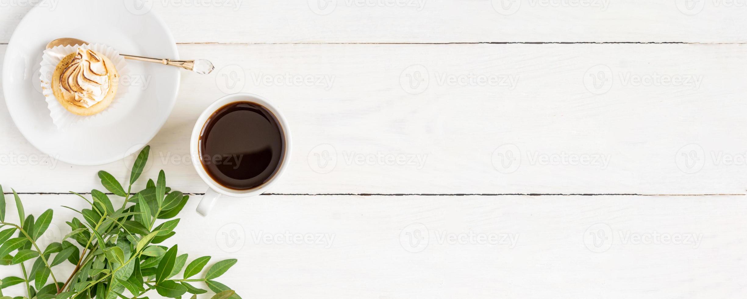 Cup of black coffee with mini cake on white table. The concept of breakfast, flat lay, top view. Banner photo