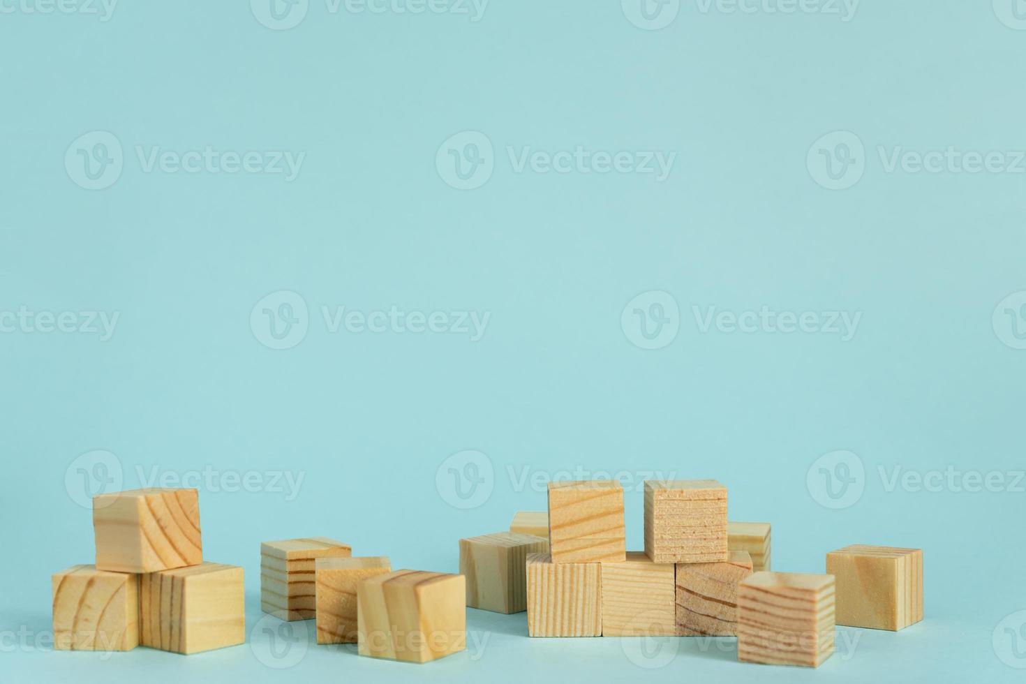 Construction of wooden cubes on blue background with copy space. Mockup composition for design photo