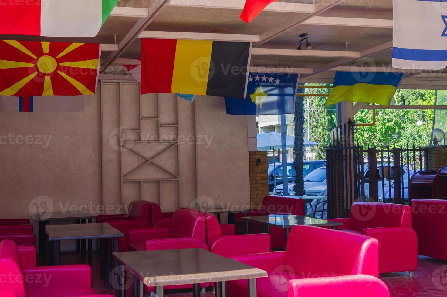 interior of street cafe decorated with national flags under the ceiling photo