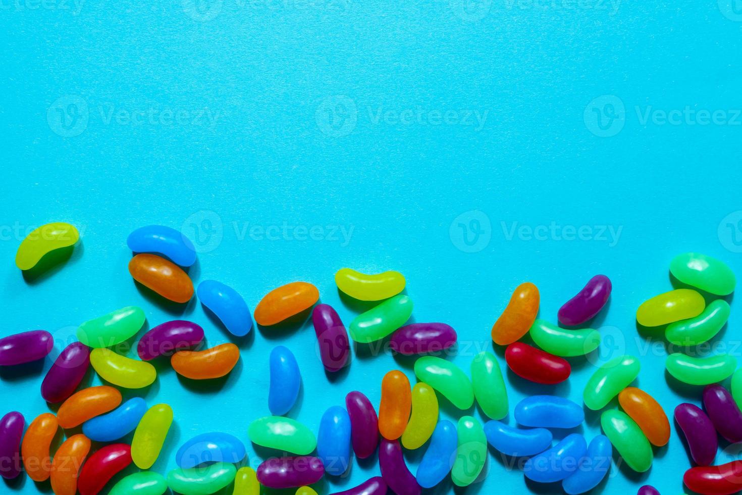 Assorted Jelly Beans border with copyspace on blue background. photo