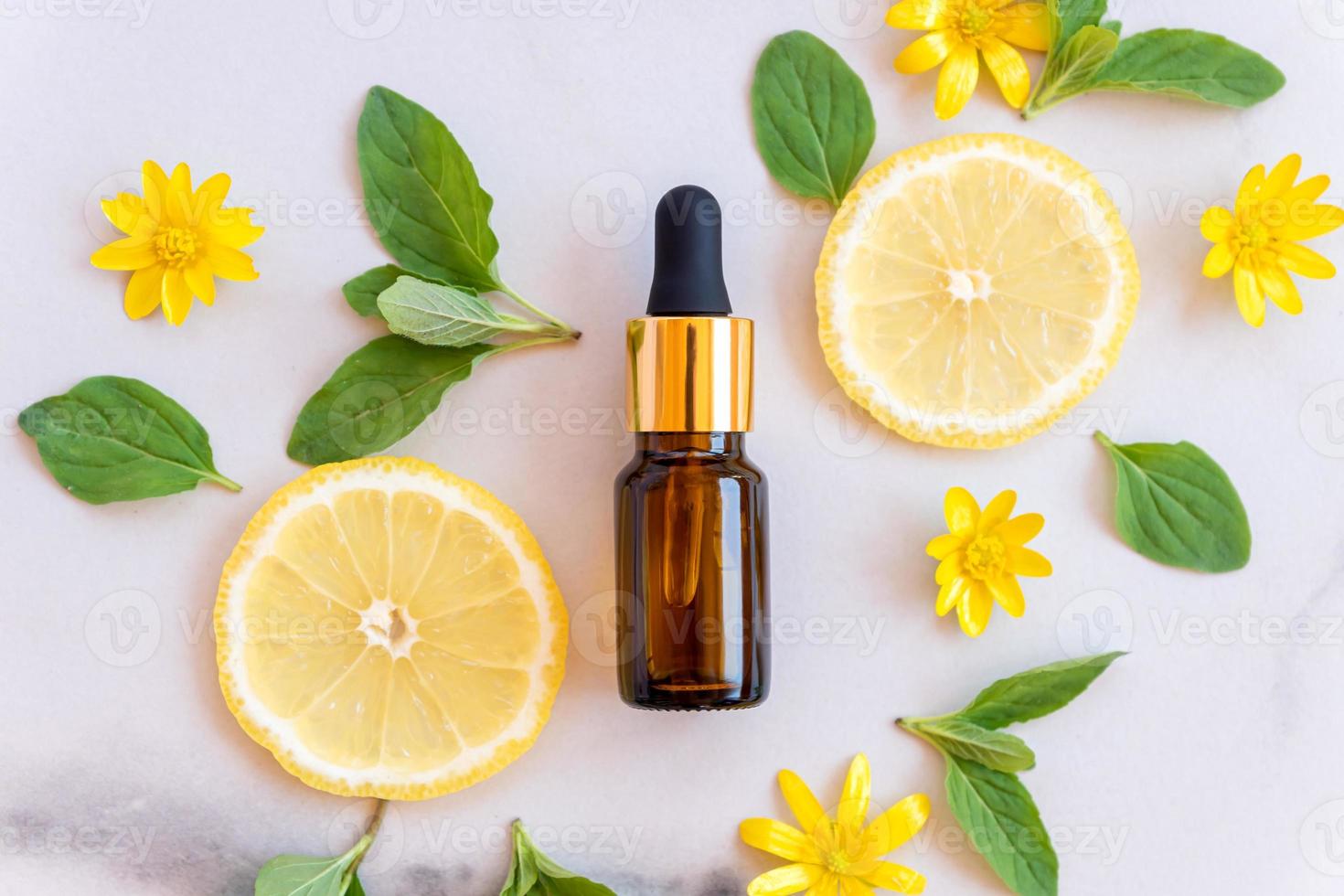 Vitamin C serum in cosmetic bottle with lemon citrus slices with green leaves on white background. Citrus essential oil, cosmetics aromatherapy. Organic SPA cosmetics with herbal ingredients. photo