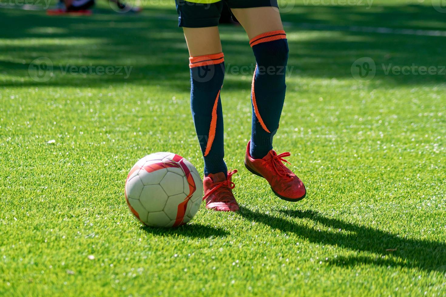 Teenager kicking the ball on a pitch. Junior Football Training Session. Football Education Background with copy space photo