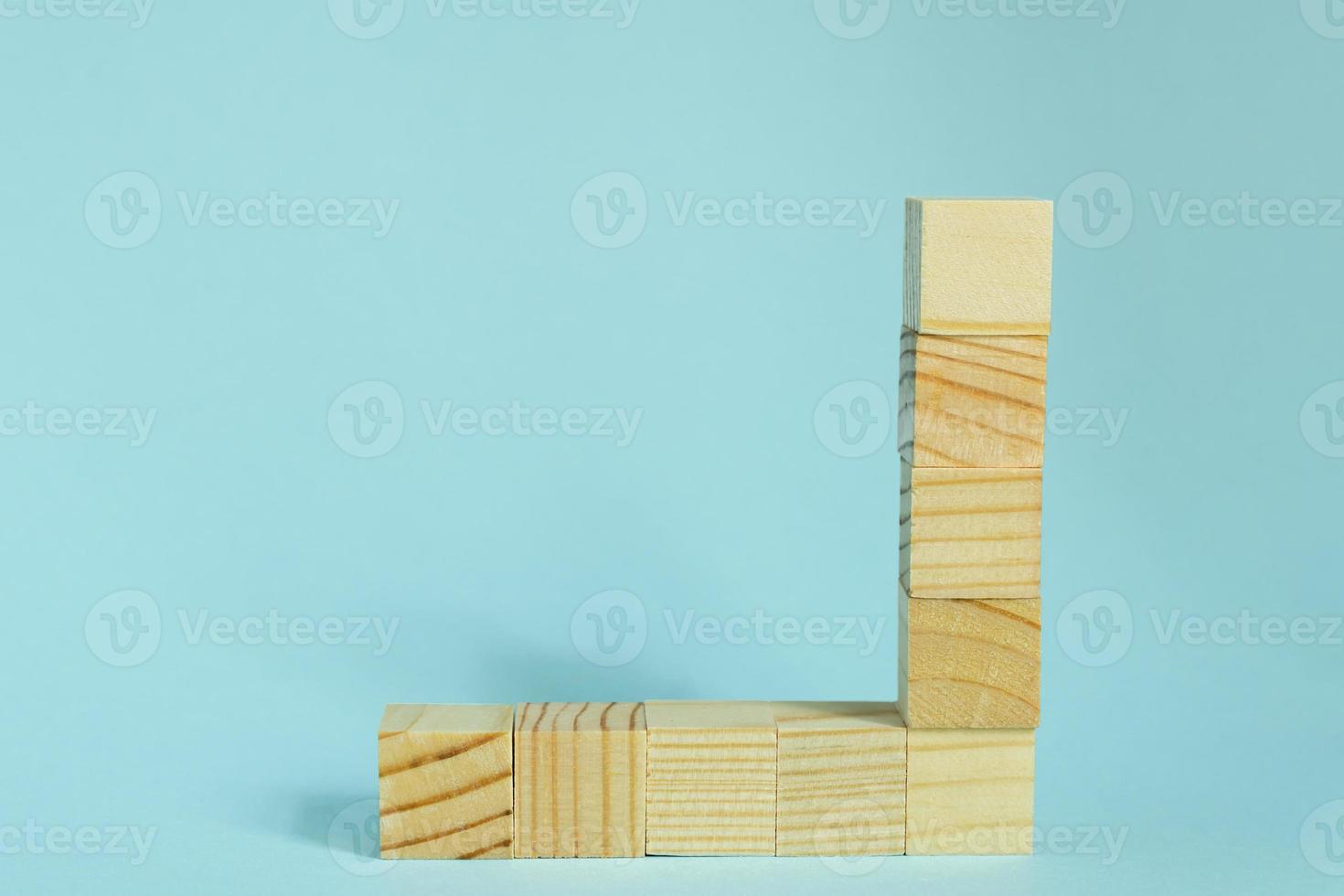 Construction of wooden cubes on blue background with copy space. Mockup composition for design photo