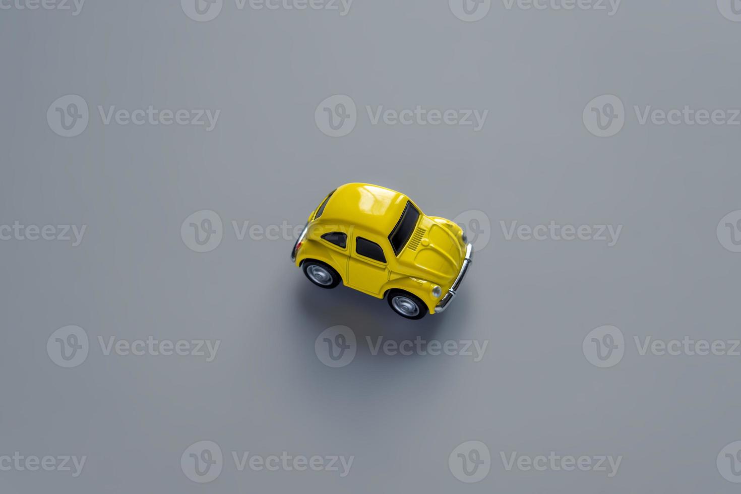 Flat lay in a trendy 2021 new colors. Illuminating Yellow and Ultimate Gray. Color of the Year 2021. Retro toy car on grey background with copy sapce photo