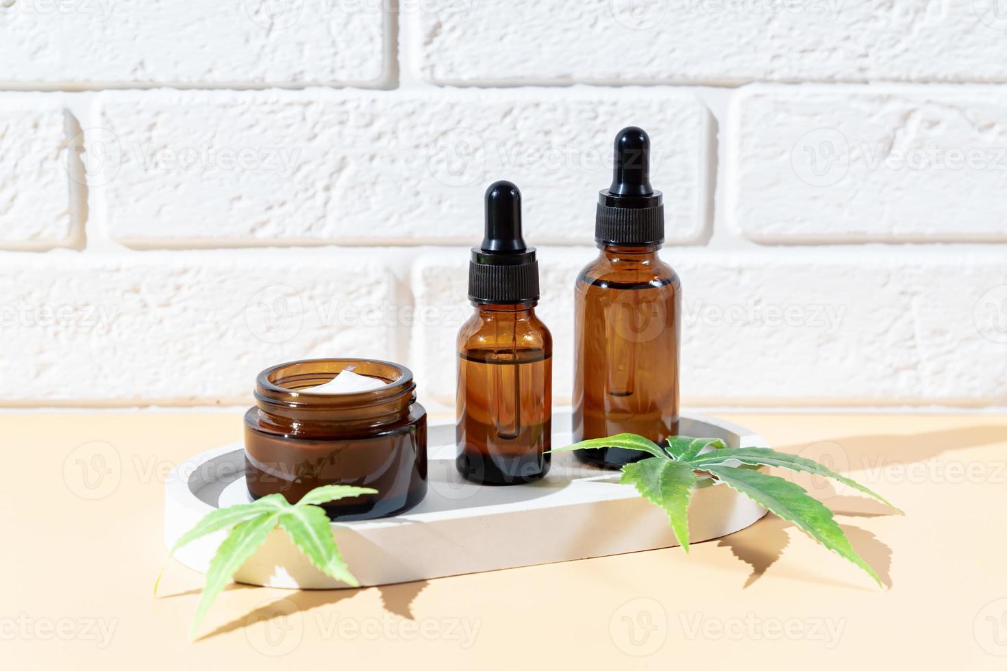 Hemp cbd oil serum in glass dropper bottle with cannabis leaves, Moisturizing cream, Serum, lotion, essential oil. Cannabis leaves with skincare cosmetic product. Natural eco cosmetics photo