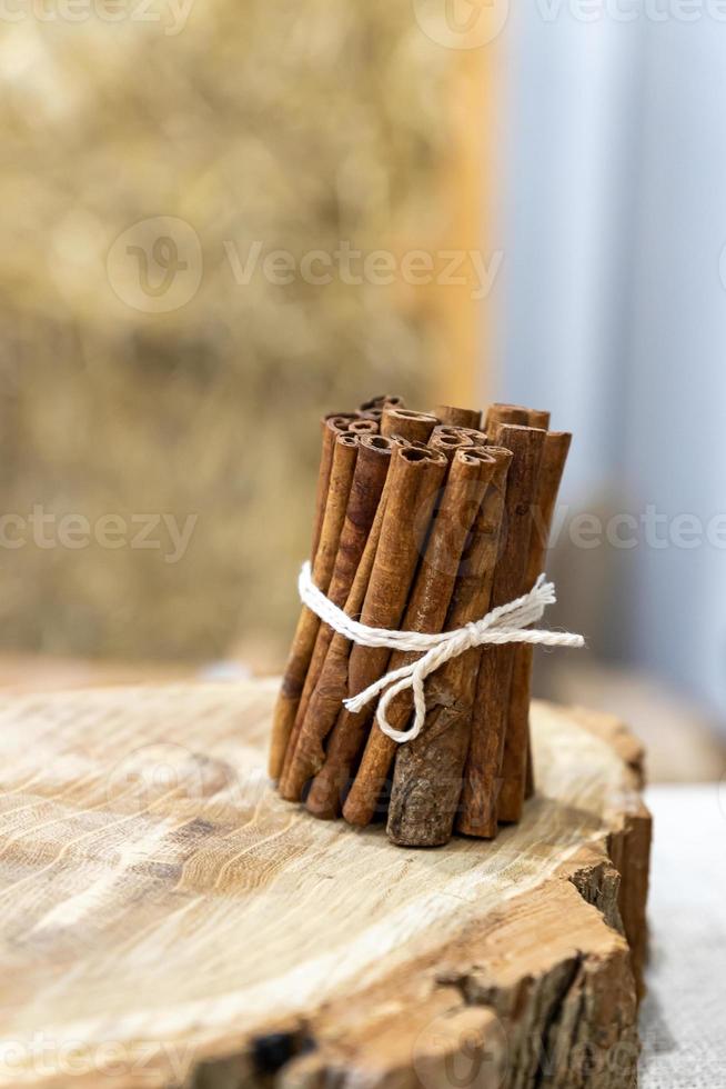 montón de palitos de canela en un tocón de madera. condimento alimentario natural foto