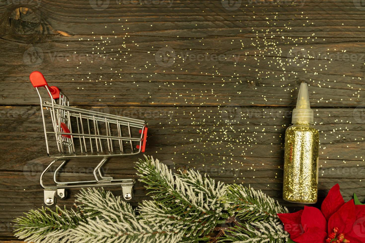 Happy New year 2021 celebration. shopping cart with golden confetti on wooden background. Flat lay with copy space photo