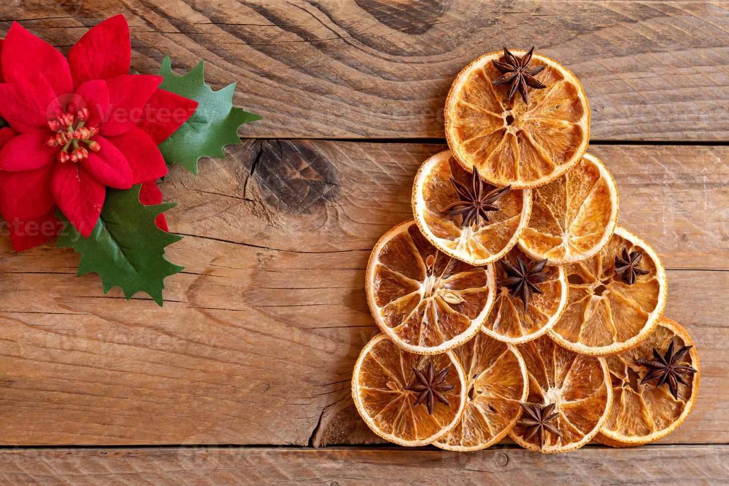Christmas flat lay composition. Christmas handmade Tree made of dried oranges and anise on wooden background. Winter holidays, new year concept. Still life. Top view, copy space for text photo
