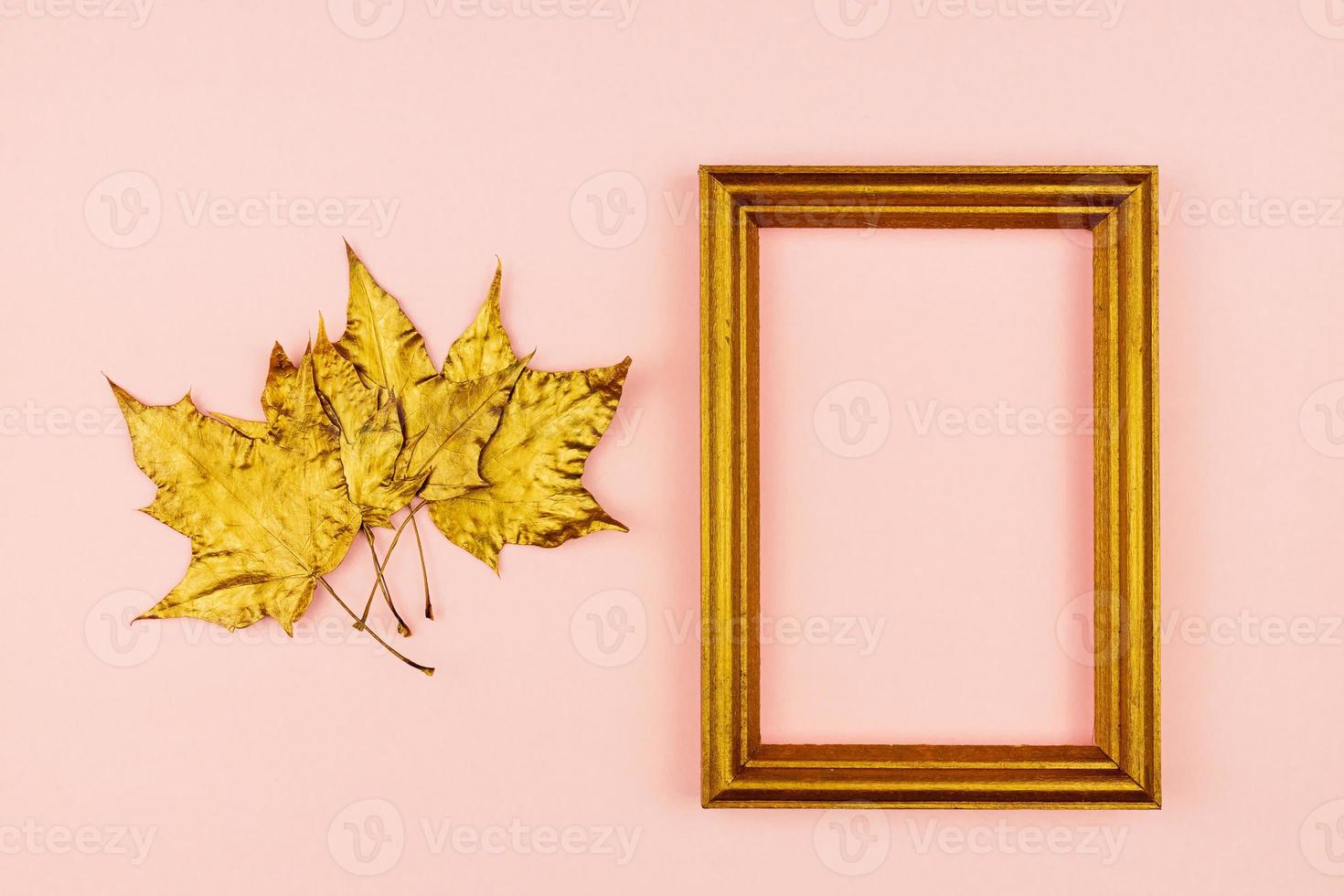 Autumn bouquet of golden painted maple leaves on pink background. Trendy concept. Flay lay in minimalism style. photo