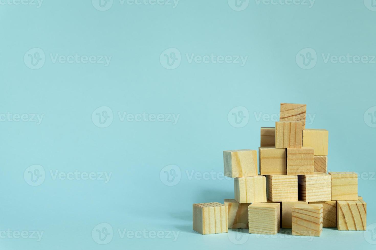 Construction of wooden cubes on blue background with copy space. Mockup composition for design photo