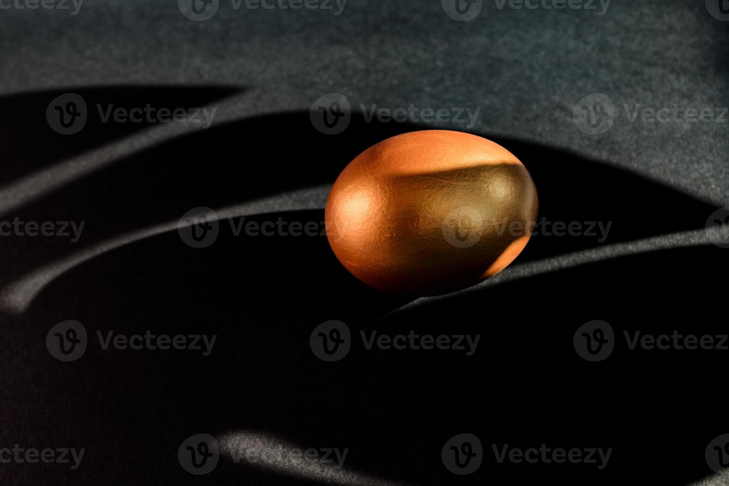 Golden egg on black background . A symbol of making money and luxury life. copy space photo