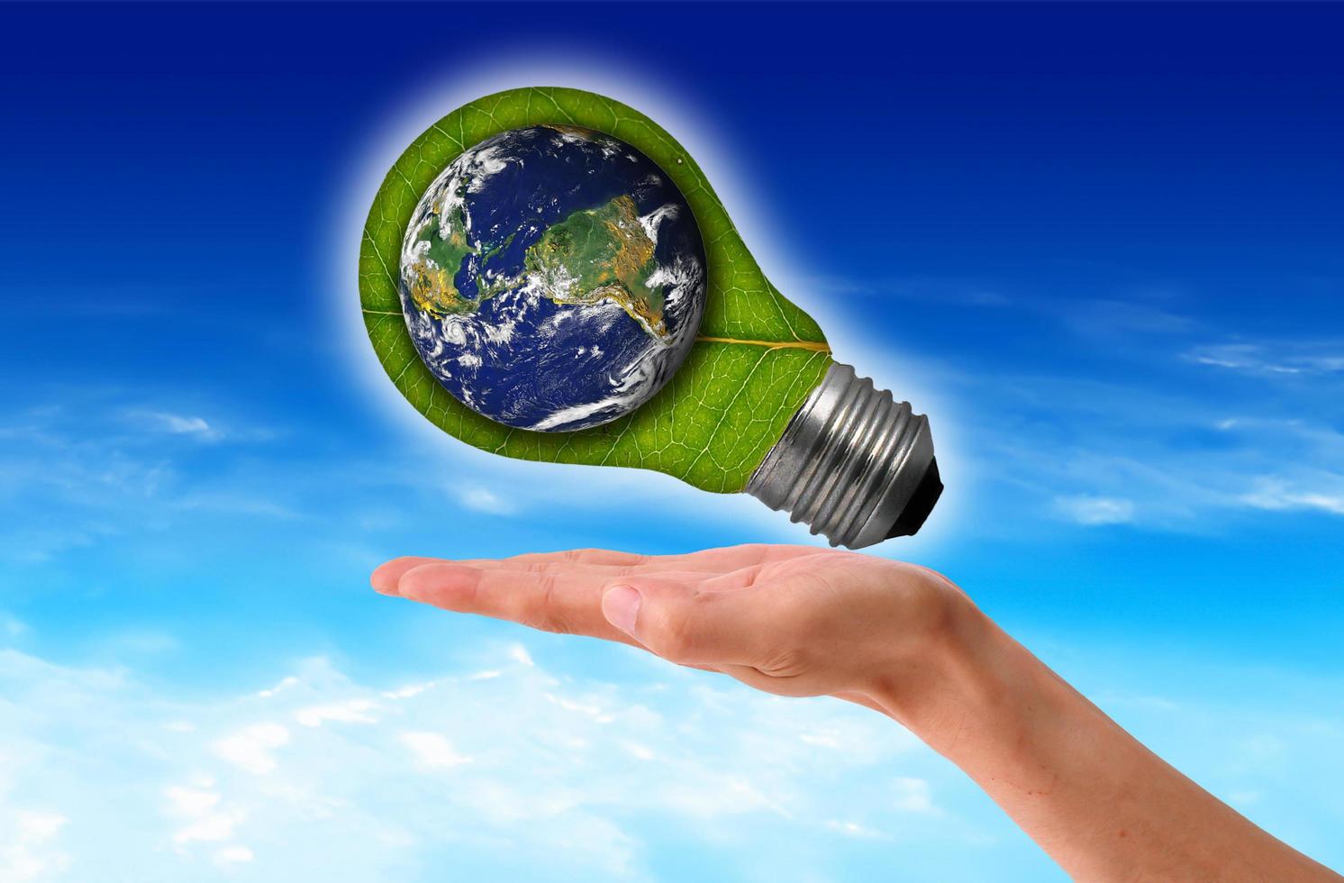Ecological concept, leaf and lamp mixed together with hand photo