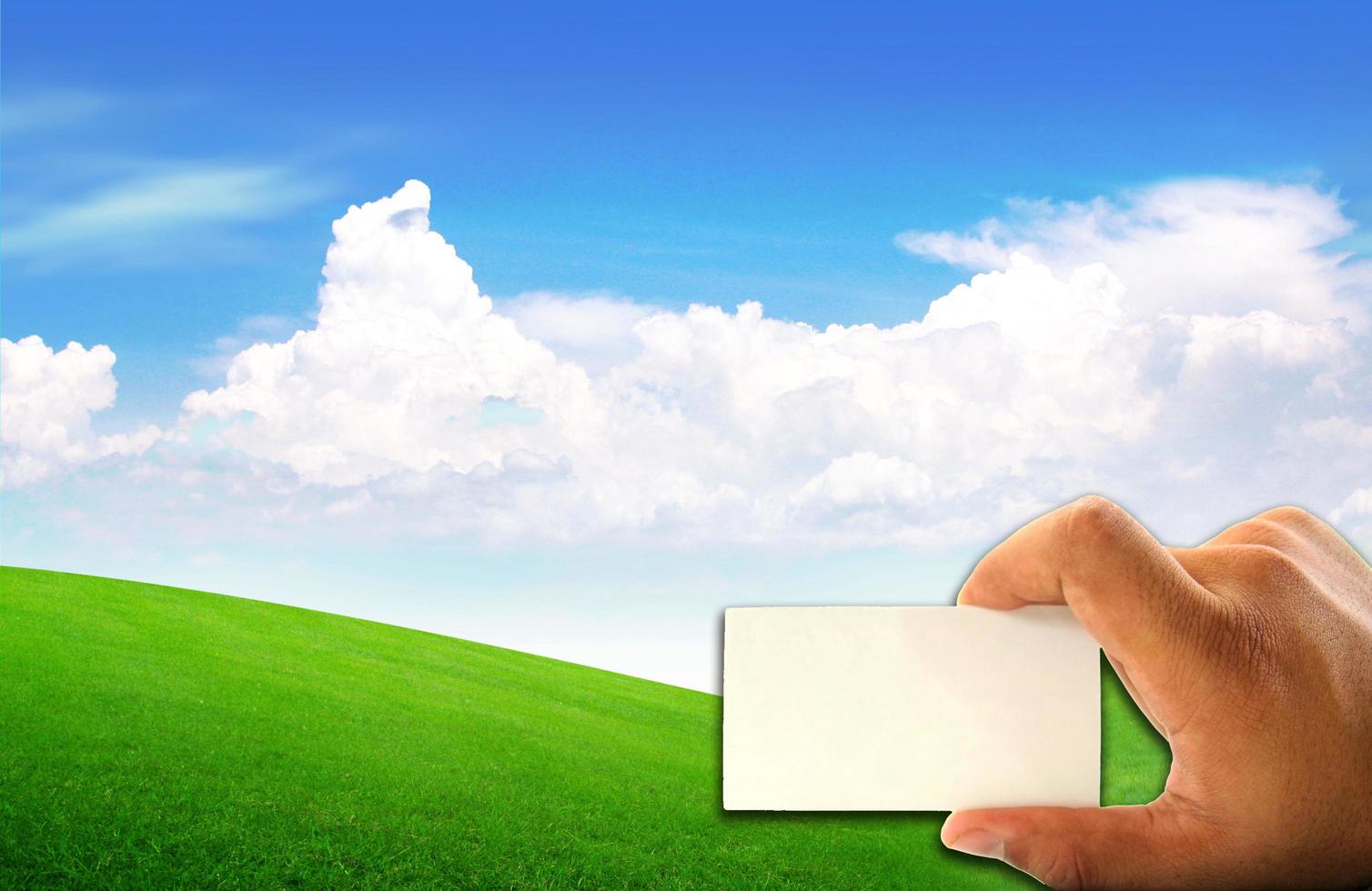 white paper in hand and green field photo