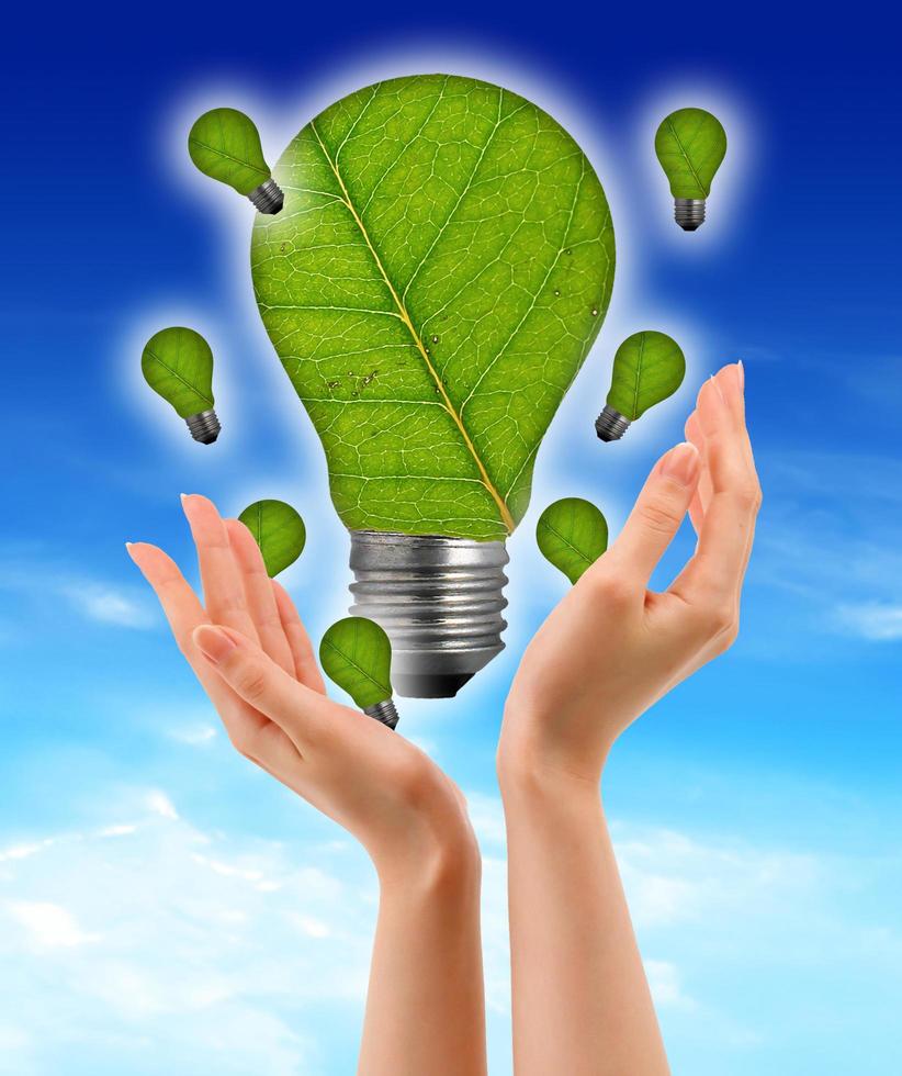 Ecological concept, leaf and lamp mixed together with hand photo