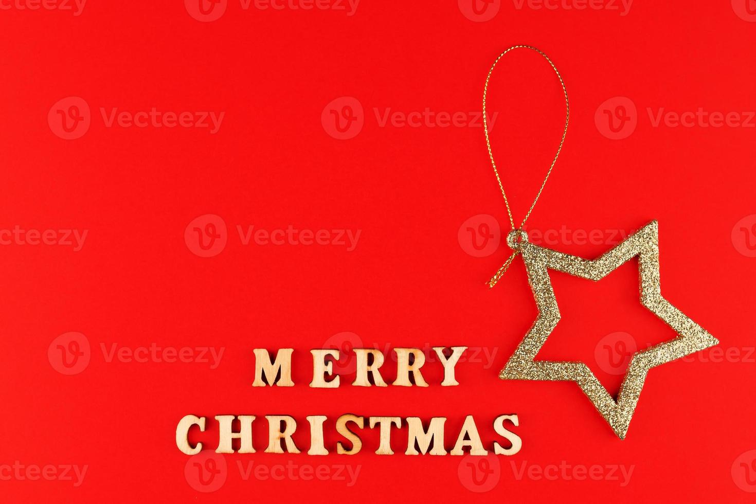 Festive greeting card. Merry christmas lettering on red background with golden glittering star. photo