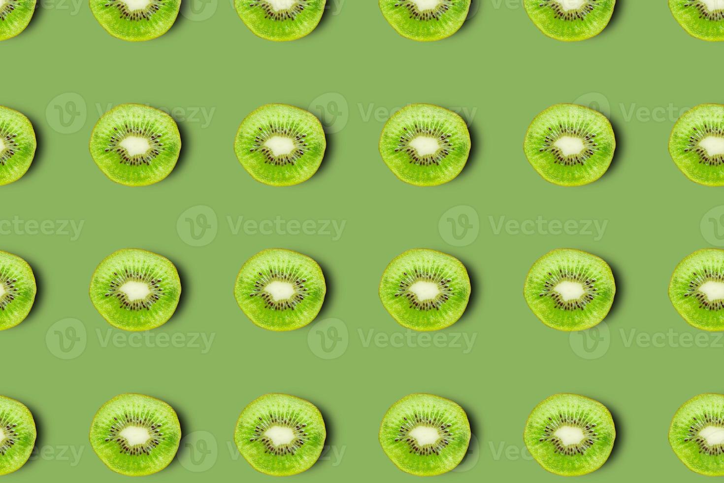 patrón de kiwis sobre fondo verde, rodajas similares. foto