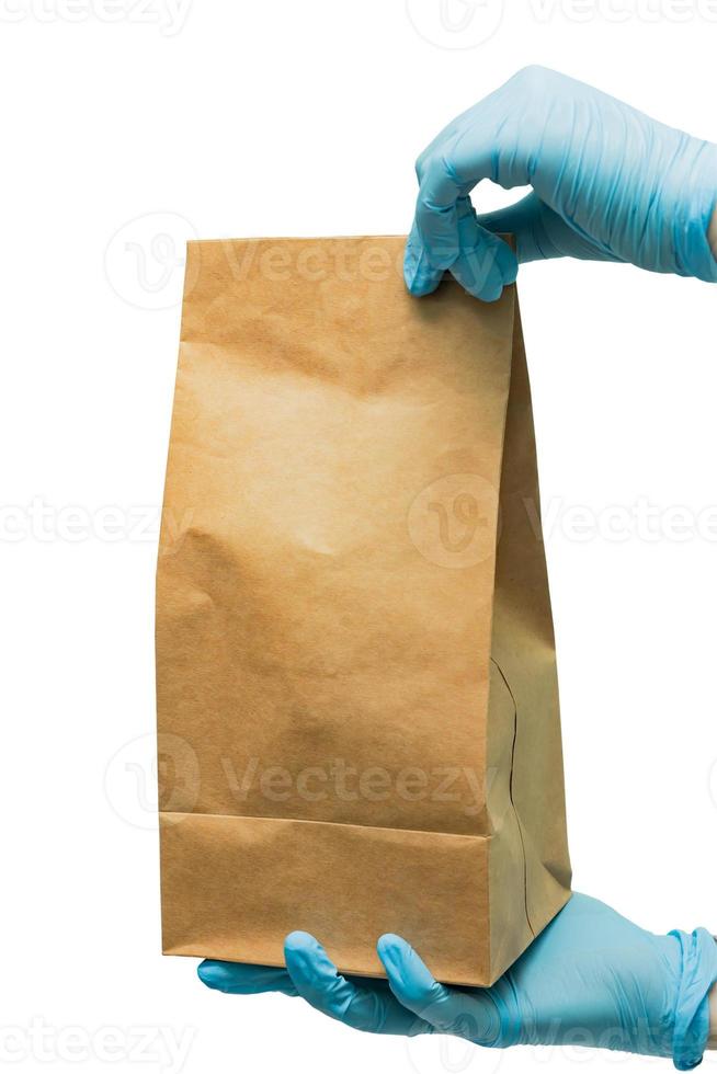 Close up female hold in hand glove clear blank craft paper bag for takeaway isolated on white background. Packaging template mockup. Delivery service concept. photo