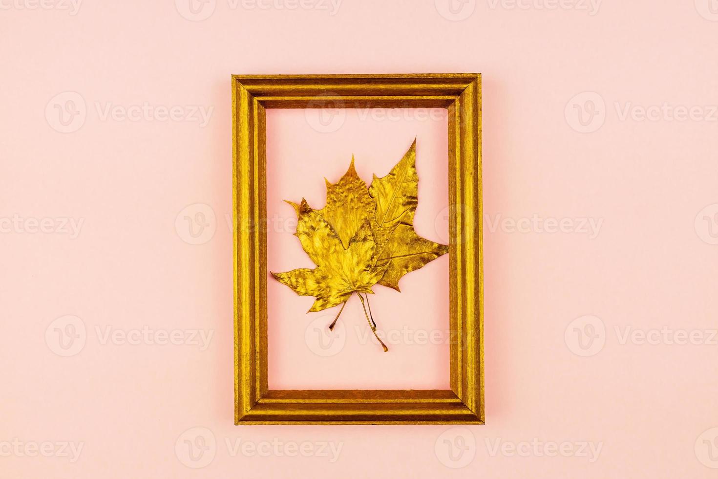 Autumn bouquet of golden painted maple leaves on pink background. Trendy concept. Flay lay in minimalism style. photo