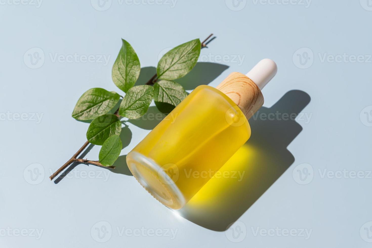 Cosmetic pipette with vitamin C. Transparent oil close-up. serum unbranded package. A sample of a cosmetic product. Blue background. photo