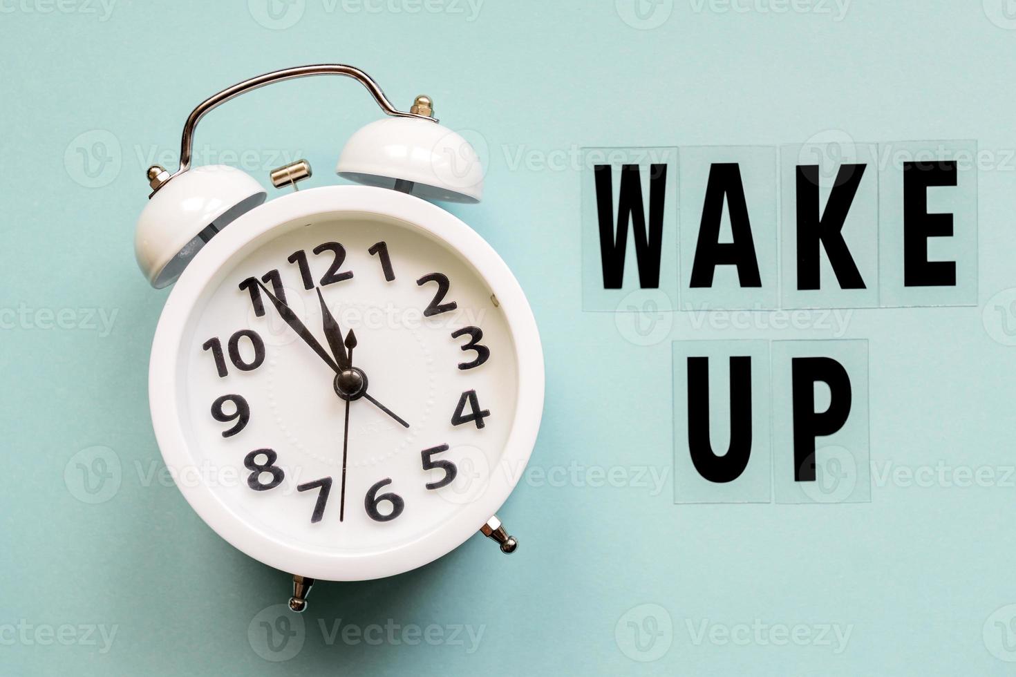 Wake up inscription. Alarm clock with wake up text on blue background photo