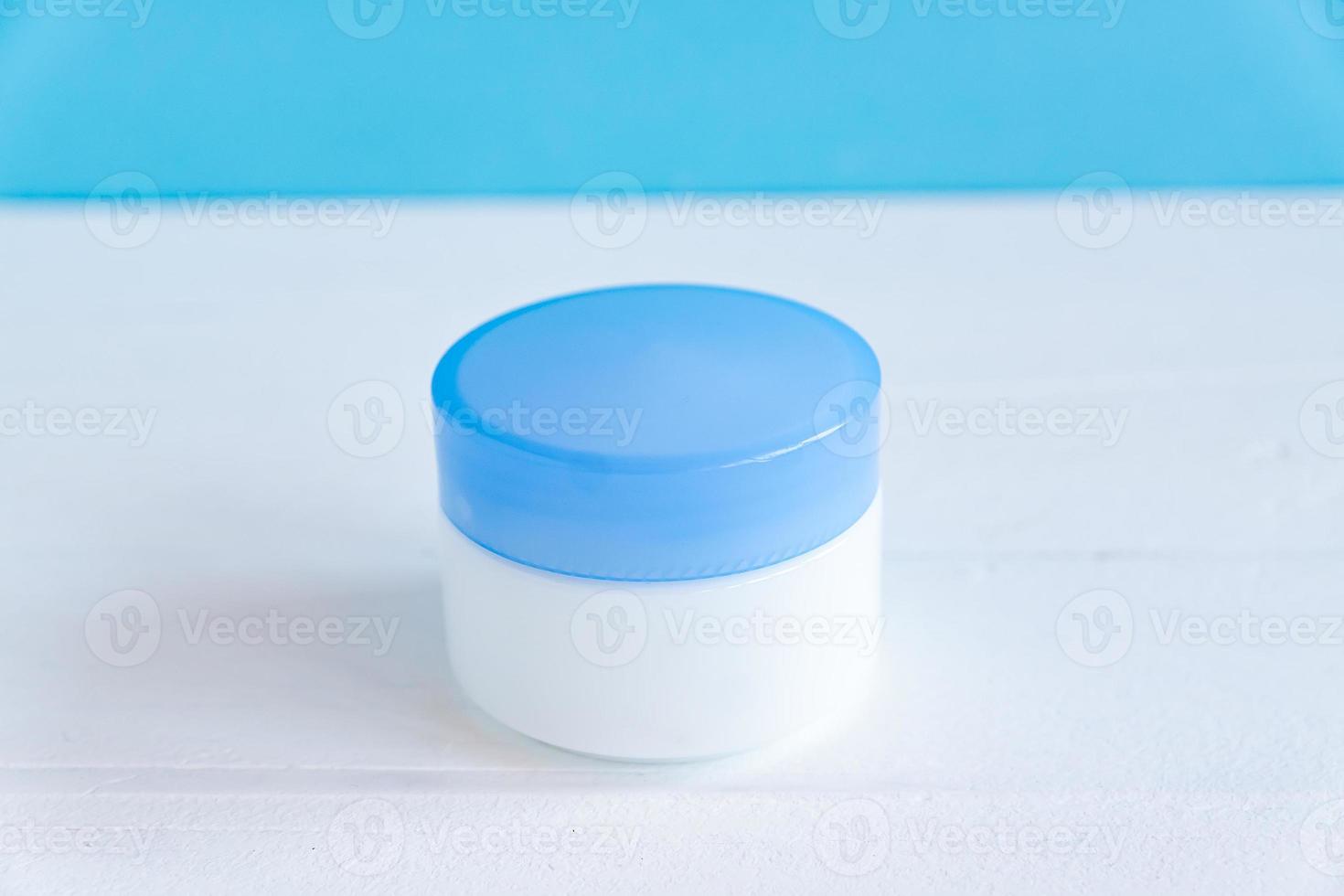 Natural moisturising or collagen gel in white plastic jar on on white wooden background. spa cosmetics and skincare concept closeup photo