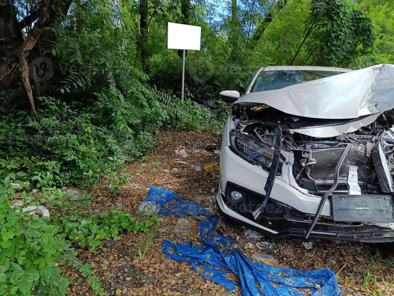 Destroyed car in car crash traffic accident on city road. Smashed broken front, left in the wasteland. Auto life and insurance. photo