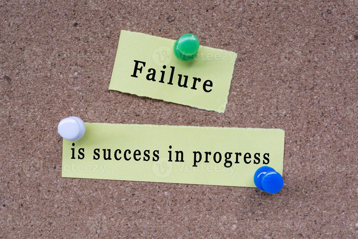 Failure is success in progress words on stick note pinned to a cork notice board photo