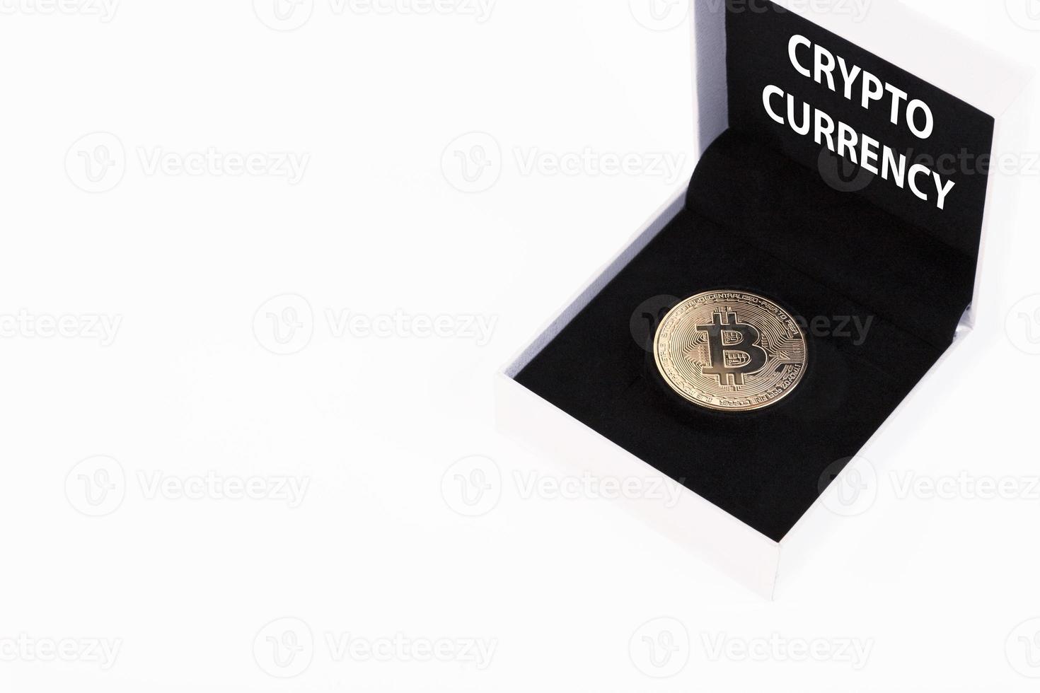 Cryptocurrency text, golden bitcoin in a white gift box with black velvet on a white background. Copy space. photo