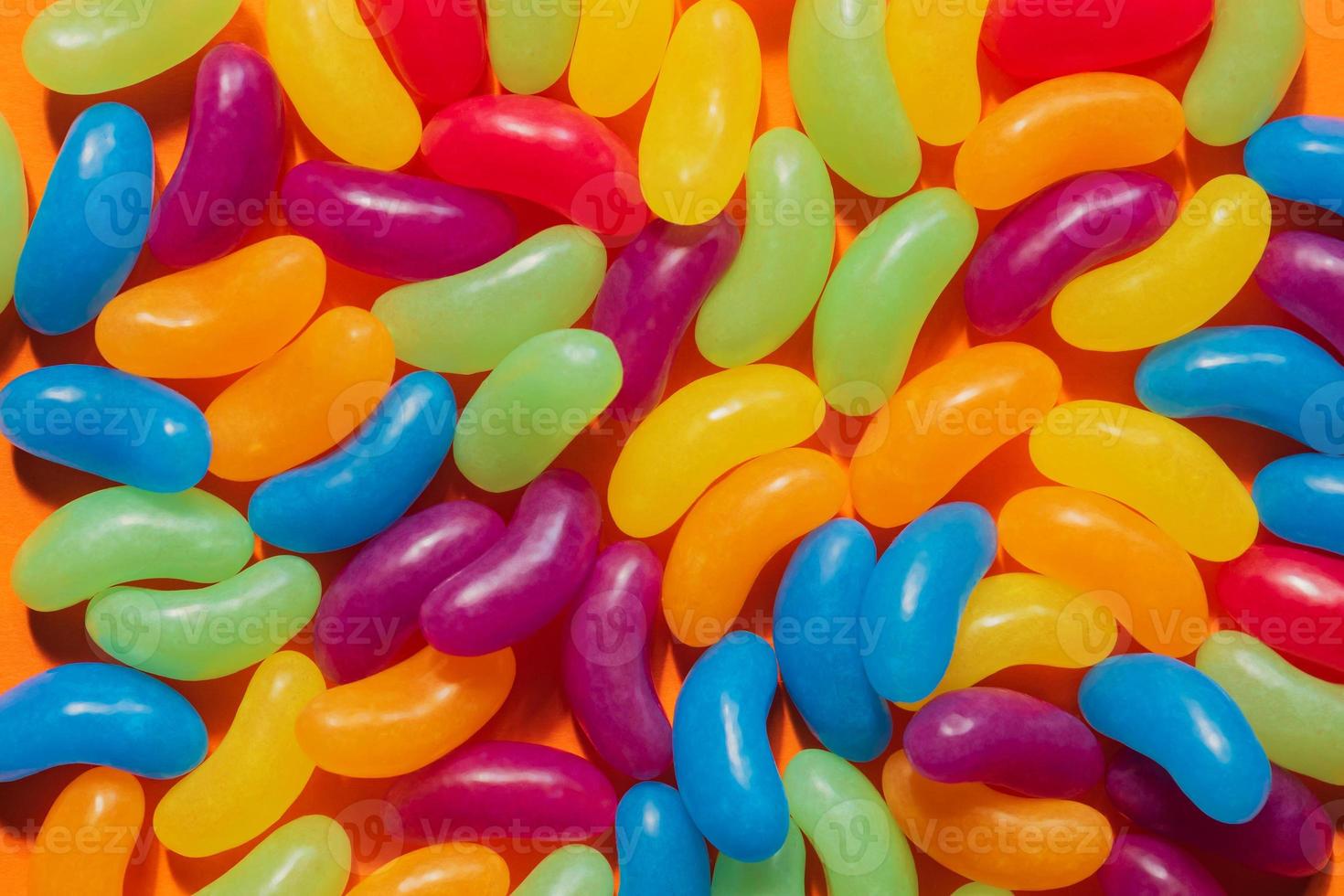 Assorted Jelly Beans border with copyspace on orange background photo