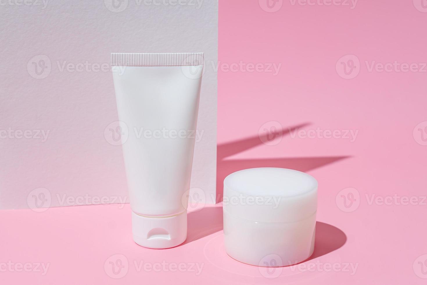 concepto de cuidado de la piel médica de spa de belleza saludable con botella de crema de loción cosmética y tubo de embalaje sobre fondo rosa con pared blanca. estilo minimalista de moda foto