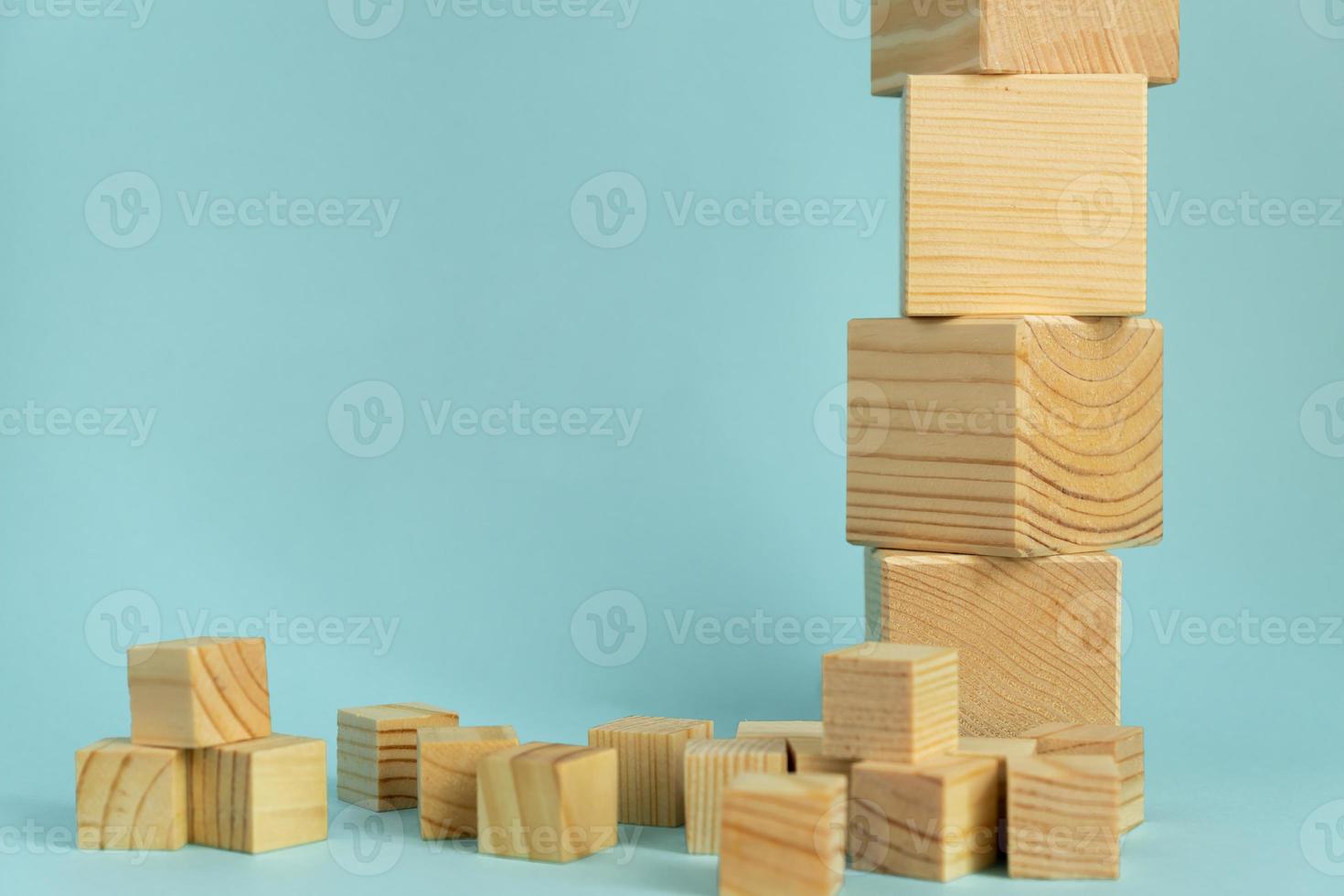 Construction of wooden cubes on blue background with copy space. Mockup composition for design photo