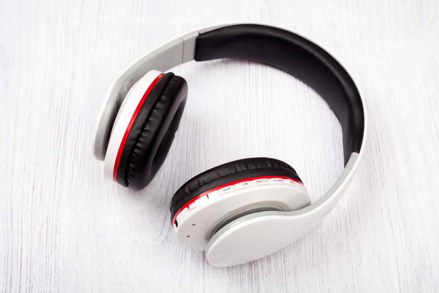 Bluetooth headphones on white wood background photo