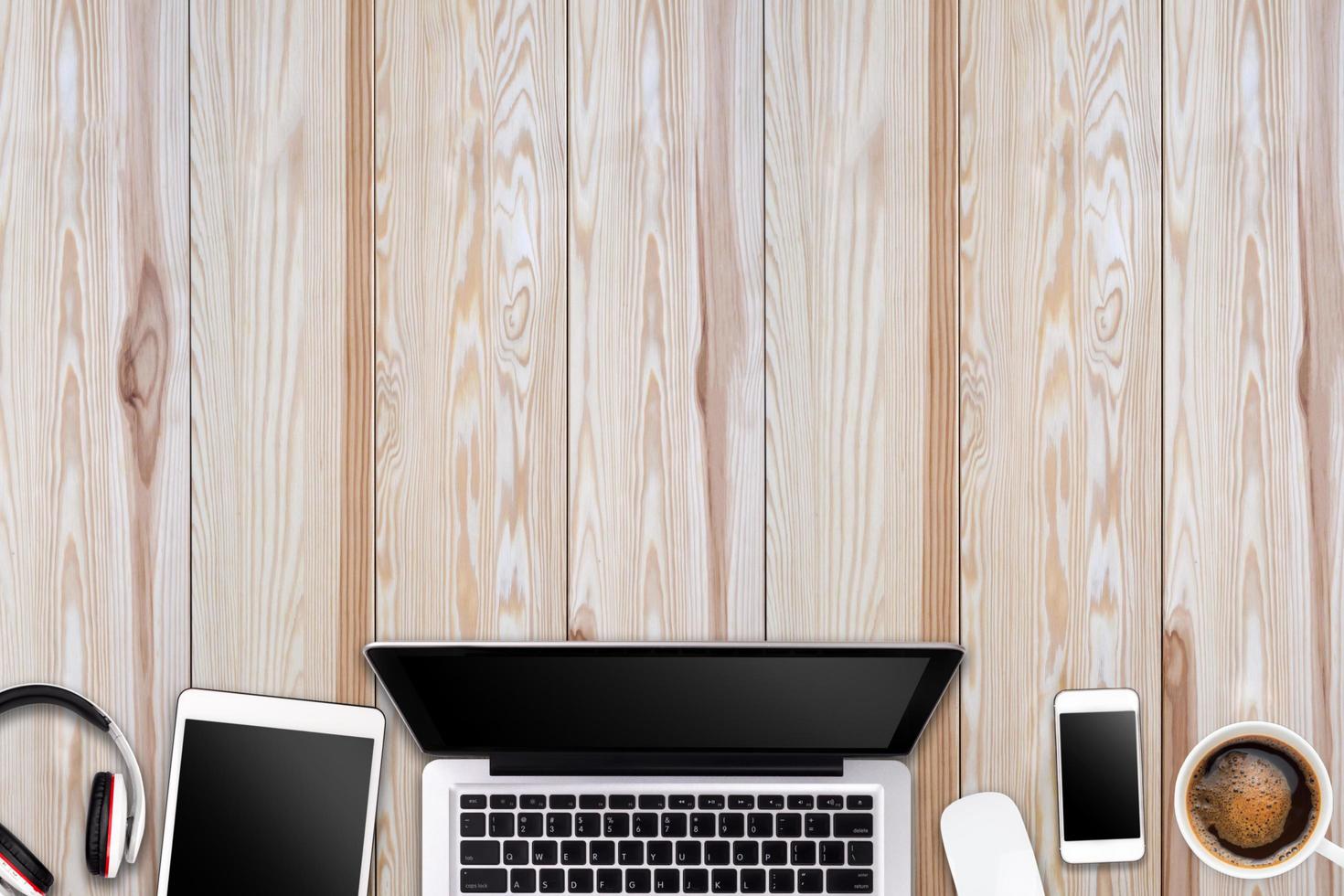 Modern workspace with laptop tablet, smartphone and coffee cup copy space on wood background. Top view. Flat lay style. photo