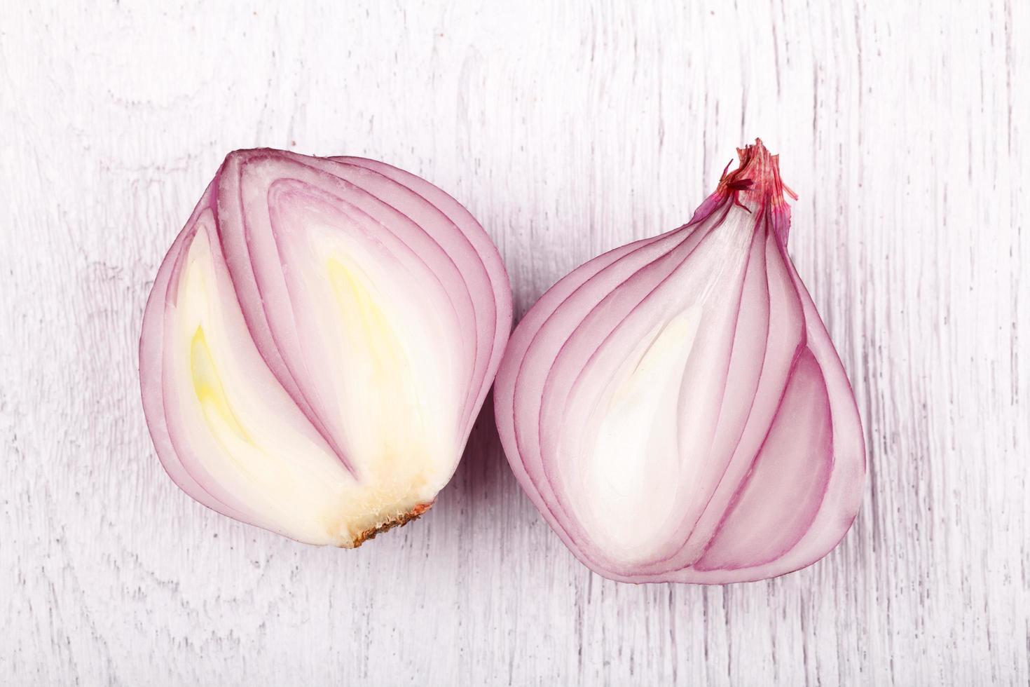 red slice onion bulb on white wood table photo
