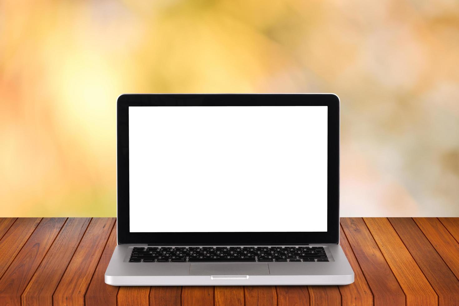 Front view of the laptop is on the work table with bokeh green background photo