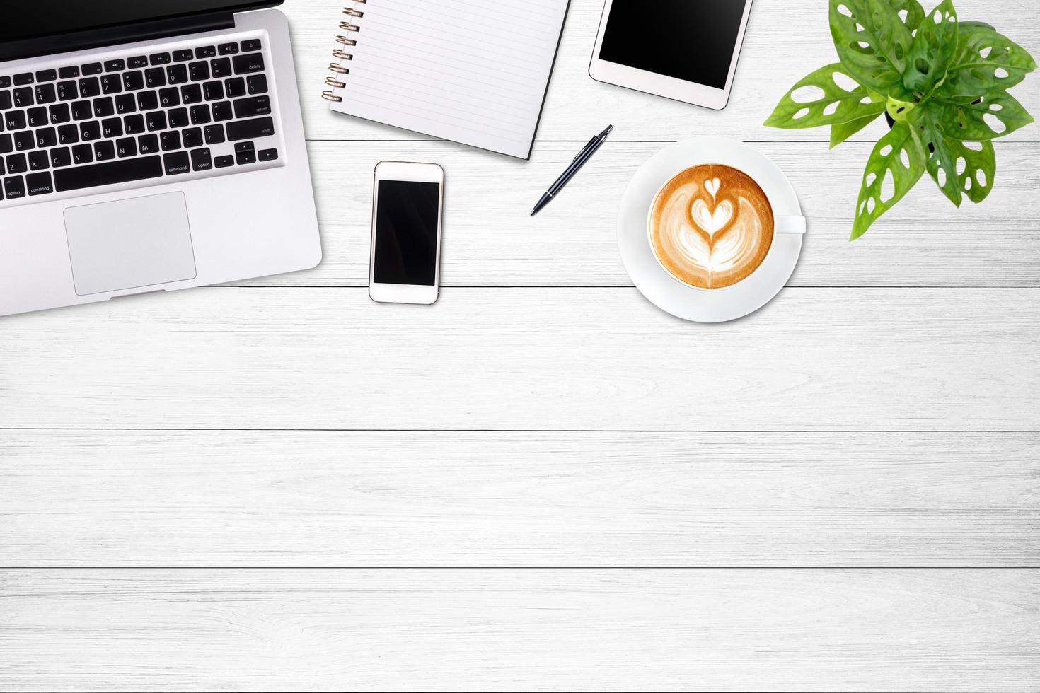 Modern workspace with laptop tablet, smartphone and coffee cup copy space on white wood table background. Top view. Flat lay style. photo